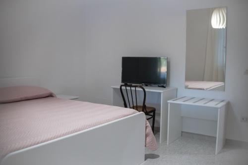 a bedroom with a bed and a tv and a chair at LA Dimora di Maria in Laterza