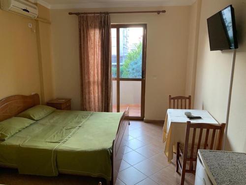 1 dormitorio con cama, mesa y ventana en Hotel Palma, en Durrës