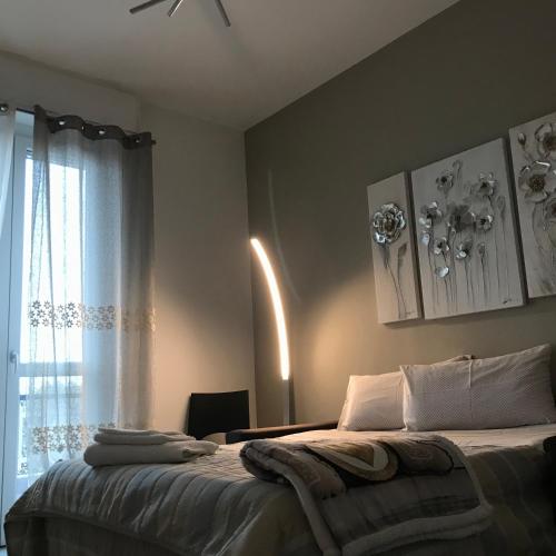a bedroom with a bed with a ceiling fan and a window at Cà Nicola Cortemaggiore città d’arte in Cortemaggiore