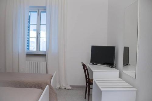 a bedroom with a bed and a desk with a television at LA Dimora di Maria in Laterza