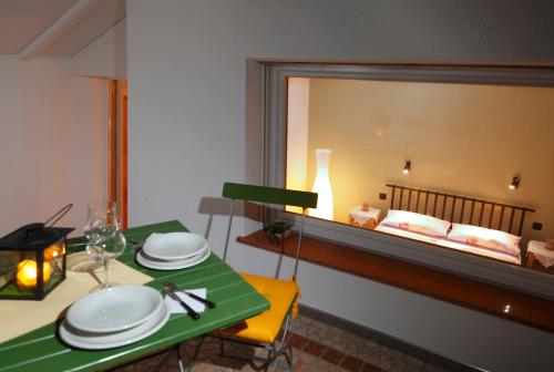 a dining room with a table and a bed in the window at viaDolceVita - Blaue Gästewohnung in Lana
