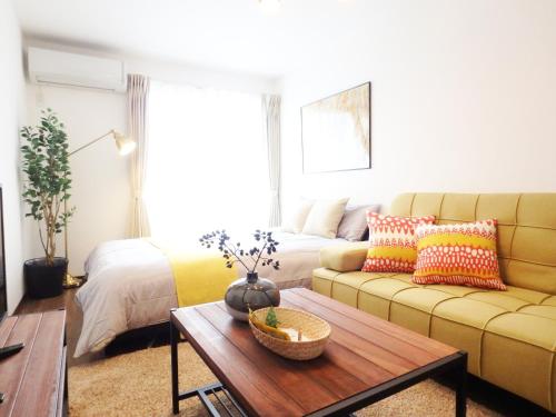 a living room with a couch and a coffee table at Apartment Hotel KANSO in Kyoto