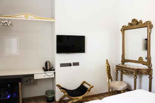 a bedroom with a mirror and a chair and a bed at 9 Muses Hotel in Larnaka