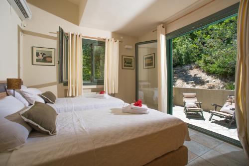 a bedroom with two beds and a large window at Basilica Estate in Porto Ozias