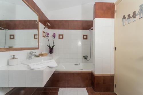 a bathroom with a tub and a sink at Basilica Estate in Porto Ozias