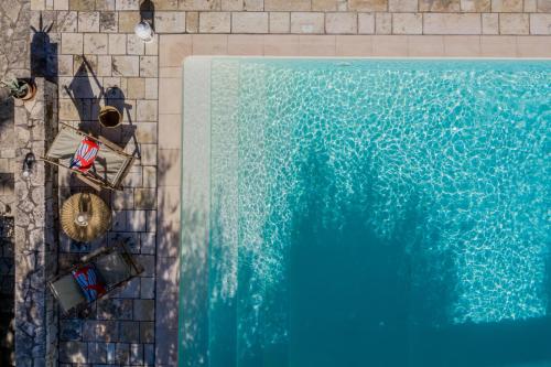 an overhead view of a swimming pool with chairs next to it at Basilica Estate in Porto Ozias