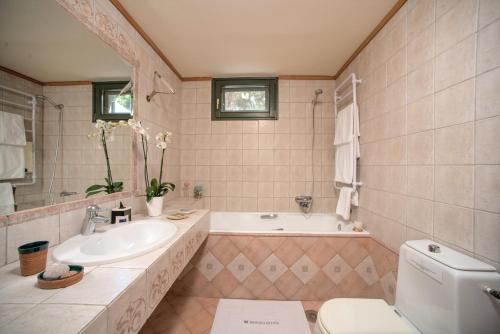 La salle de bains est pourvue d'un lavabo, d'une baignoire et de toilettes. dans l'établissement Basilica Estate, à Porto Ozias
