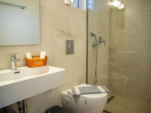 a bathroom with a toilet and a sink and a shower at Cypress Garden Villas in Svoronata
