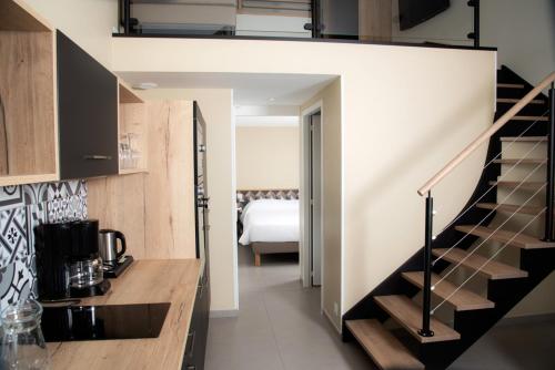 a kitchen with a staircase leading to a bedroom at Hotel Les Dunes in La Tranche-sur-Mer