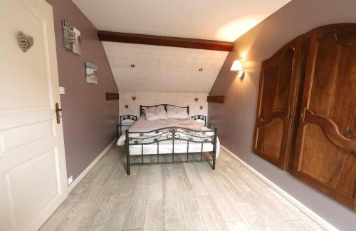 una camera con letto e pavimento in legno di gîte de la Girouette a Englesqueville-la-Percée