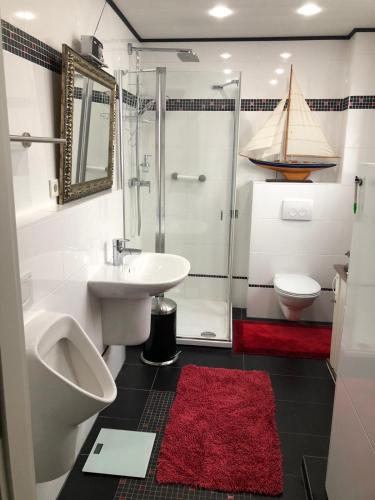 ein Badezimmer mit Waschbecken, Toilette und Dusche in der Unterkunft Ferienwohnung Schwede in Surendorf