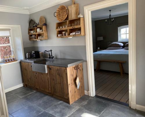 una cocina con fregadero y una cama en una habitación en Cassehof, en Ospel