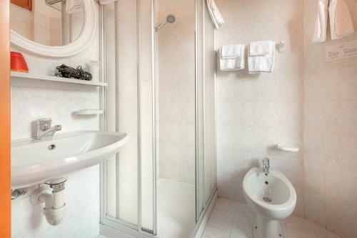 uma casa de banho com um lavatório, um WC e um chuveiro em Hotel La Rotonda em Tirano
