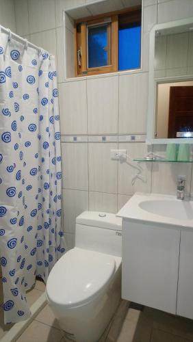 a bathroom with a toilet and a sink at Jinsha Haiyunbian I Homestay in Nangan