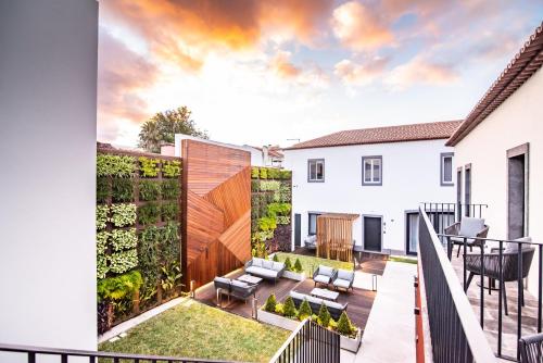 un patio al aire libre con una valla y un jardín en Villa Esmeralda en Ponta Delgada