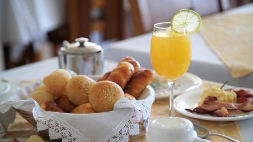 un tavolo con un piatto di cibo e un bicchiere di succo d'arancia di Ramada by Wyndham Furnaspark a Formiga