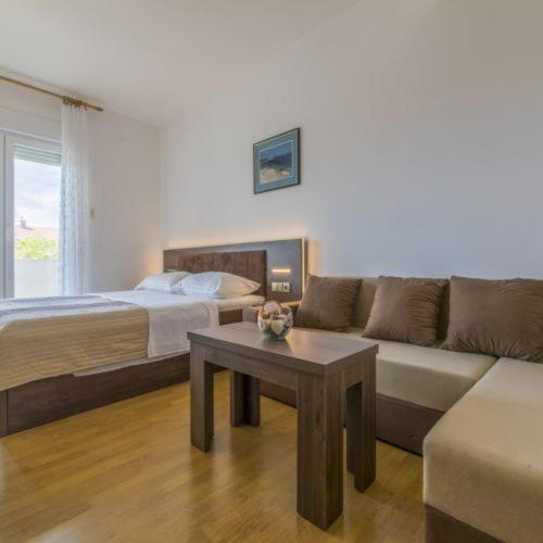 a living room with a bed and a couch and a table at Apartmani s dvije spavaće sobe 4 osobe in Selce