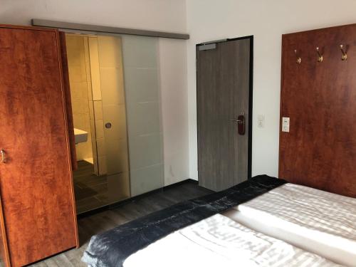 a bedroom with a bed and a closet and a shower at WH Hotels Papenburg Zentrum in Papenburg