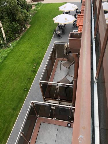 a balcony with chairs and tables on a building at WH Hotels Papenburg Zentrum in Papenburg
