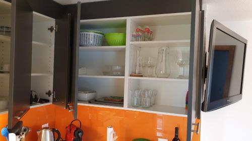 a kitchen cabinet filled with lots of glass items at Ferienwohnung Seesicht in Brunnen