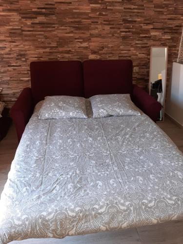 - un grand lit dans une chambre dotée d'un mur en briques dans l'établissement Studio Suquet balcony 1 min beach, 10 min Palais & Croisette Works, à Cannes