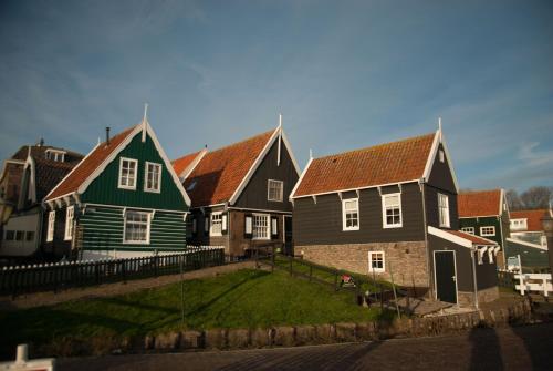 a row of houses with red roofs on a street at Apartments Waterland in Monnickendam
