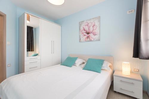 a bedroom with a white bed and a mirror at Niki in Labin