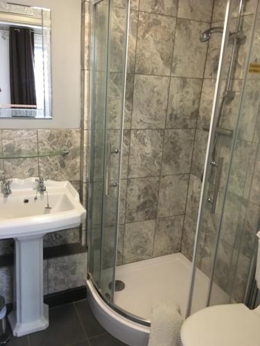 a bathroom with a shower and a sink at Old Stagecoach stables rooms only in Crewkerne