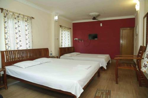 two beds in a room with red walls at Solitary Nook in Gosāba
