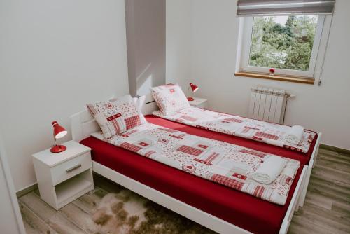 una camera con un letto e un piumone rosso e bianco di Charming & Relaxing - Feel like Home in Subotica a Subotica