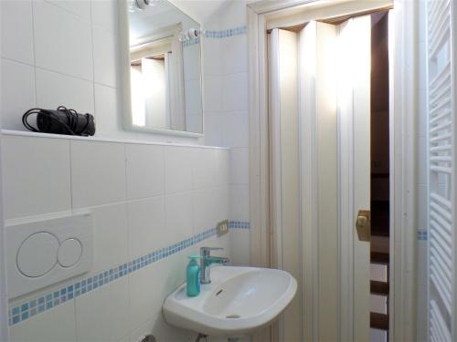 a white bathroom with a sink and a mirror at La Baia in Stresa