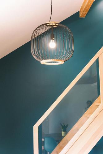 a room with a blue wall and a light fixture at L'Argalyde Esprit Pyrénées Wellness & Cycling in Ayzac-Ost
