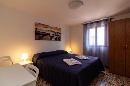 a bedroom with a bed with two towels on it at Veneziacentopercento Ole Apartment in Venice