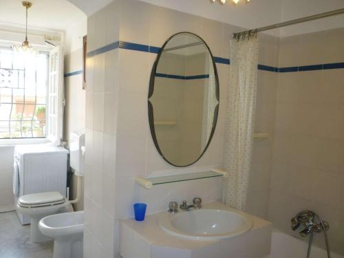 ein Badezimmer mit einem Waschbecken, einem Spiegel und einem WC in der Unterkunft LE ORCHIDEE già Lancillotto in Levanto