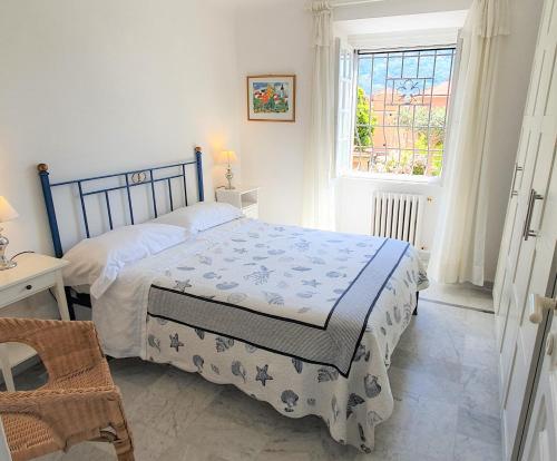 Schlafzimmer mit einem Bett und einem Fenster in der Unterkunft LE ORCHIDEE già Lancillotto in Levanto