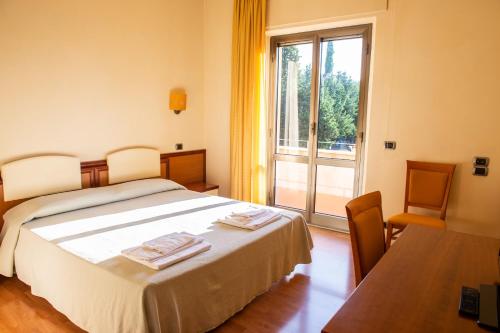 a bedroom with a bed and a large window at Hotel Ostello Settecolli Sport in Filottrano