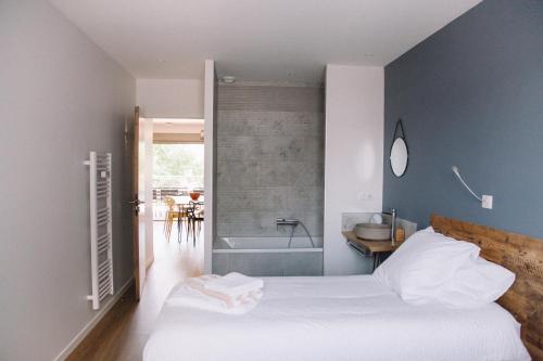 a bedroom with a bed and a bath tub at L'Argalyde Esprit Pyrénées Wellness & Cycling in Ayzac-Ost
