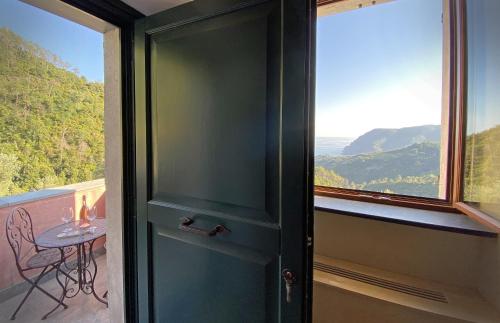 a door to a balcony with a table and a window at Agriturismo Missanega in Monterosso al Mare