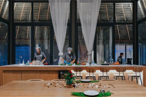 a group of three chefs preparing food in a kitchen at Island Escape Burasari in Phuket Town