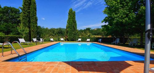 a swimming pool in a yard with chairs and trees at Torrebianca Tuscany in Rignano sullʼArno