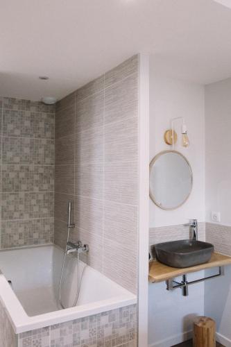 a bathroom with a tub and a sink and a mirror at L'Argalyde Esprit Pyrénées Wellness & Cycling in Ayzac-Ost