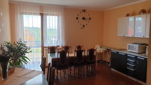 a kitchen with a table and chairs in a room at Willa Admiralska in Jarosławiec