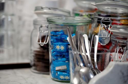 a group of glass jars with utensils on a counter at Hotel Sonne Interlaken-Matten in Interlaken