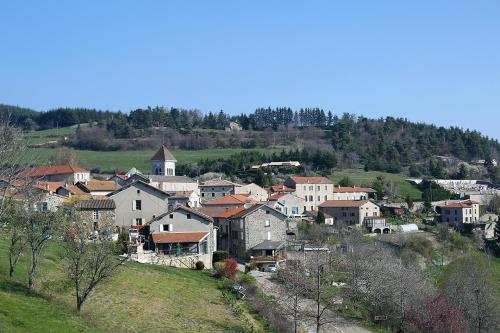 un grupo de casas en una colina con una iglesia en Les Gîtes du Couvent en Ardèche - Gîte de groupe en Nozières