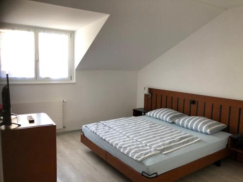 a bedroom with a large bed and a window at Hotel Restaurant Passage in Grenchen