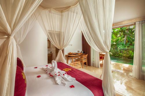 a bedroom with a bed and a canopy at The Kalyana Ubud Resort in Ubud