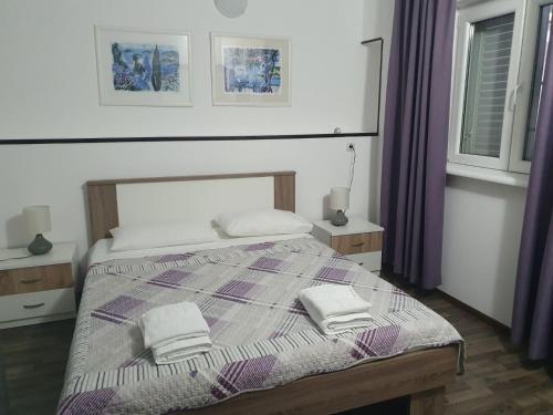 sypialnia z łóżkiem z dwoma ręcznikami w obiekcie Artemida w Medulinie