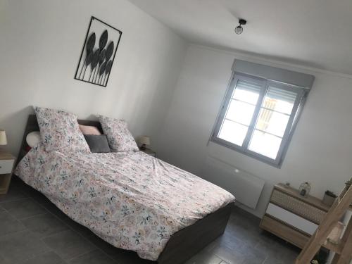 een slaapkamer met een bed en een raam bij Appartement Dulac in Seurre