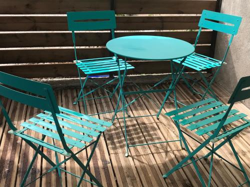 twee stoelen en een blauwe tafel en twee stoelen bij Appartement Dulac in Seurre