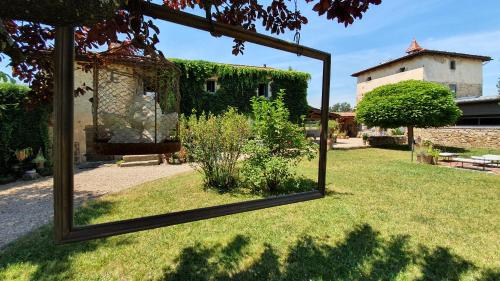 a mirror in front of a yard with a building at Le Clos Goëlle in Moissat